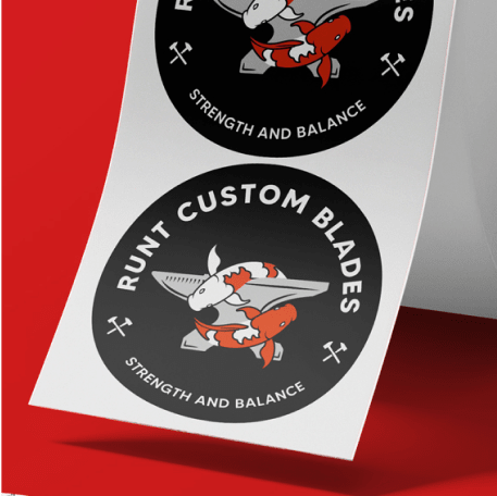 Circular logo stickers for "Runt Custom Blades" featuring a cartoon fox holding a knife with the tagline "Strength and Balance." The black stickers with white and orange details are displayed on a white sheet against a red background.