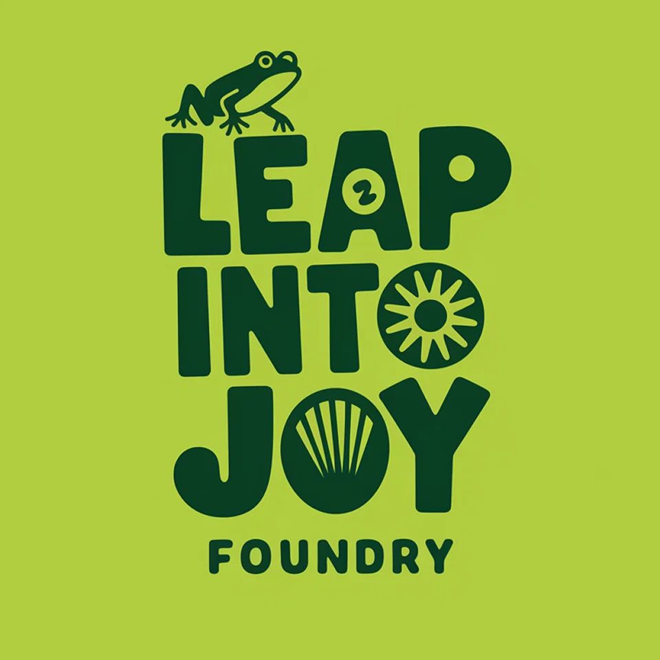 Logo of Leap Into Joy Foundry with playful bold letters and a frog icon, expressing fun and creativity.