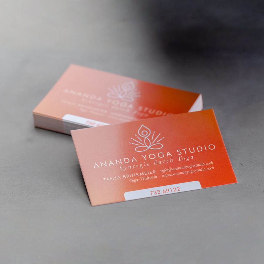 Ein Stapel hochglänzender Visitenkarten für ein Yoga-Studio.
