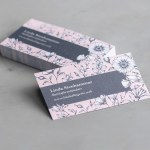 En närbild på återvunna visitkort med matt yta och med blomsterdesign för Laura Palmer.
