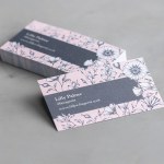 Ein Stapel Visitenkarten aus mattem Recyclingpapier mit floralem Aufdruck für eine Person namens Laura Palmer.