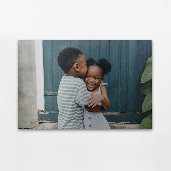 Ein Aluminiumdruck mit einem Foto von zwei Kindern, die sich umarmen.