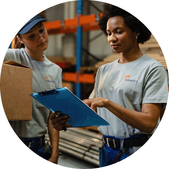 Two female workers in a warehouse wearing grey printed T-shirts showcasing the company logo