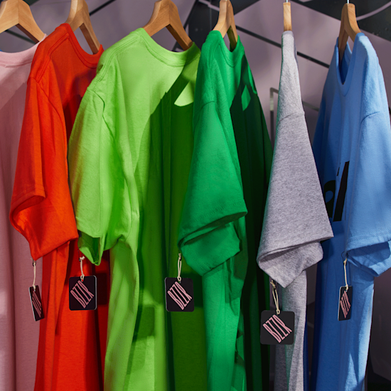 T-shirt colorate da personalizzare poste su un appendiabiti di un negozio