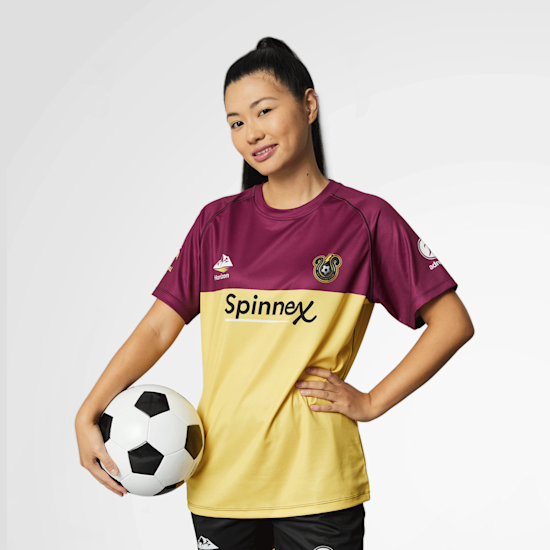Ragazza che tiene un pallone da calcio e indossa una maglia personalizzata sportiva bicolore