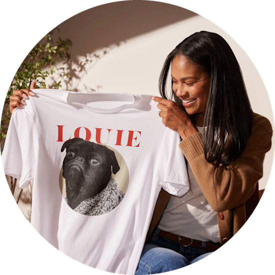 Una donna sorridente mostra una maglietta personalizzata con la faccia del suo carlino e il nome Louie