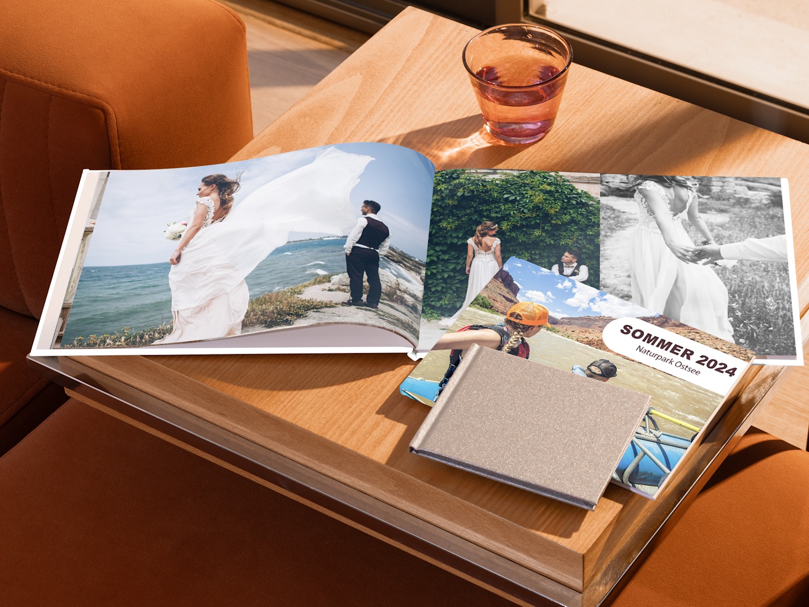 Drei Fotobücher auf einem Tisch: ein aufgeschlagenes mit Hochzeitsfotos, ein geschlossenes mit Urlaubsbildern auf dem Cover.