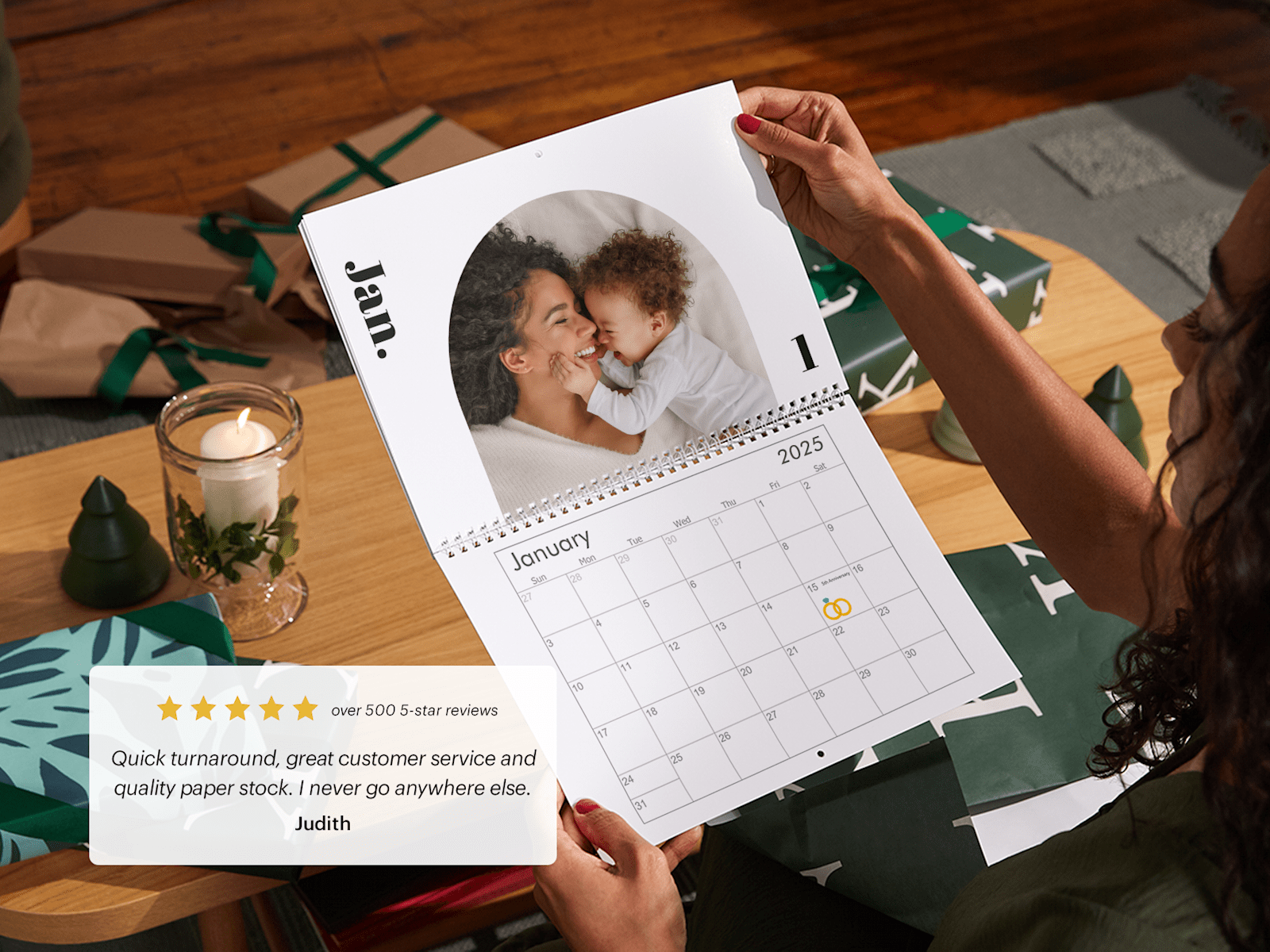 Larger version: A woman holding a photo wall calendar open to a picture of her and her infant son. 