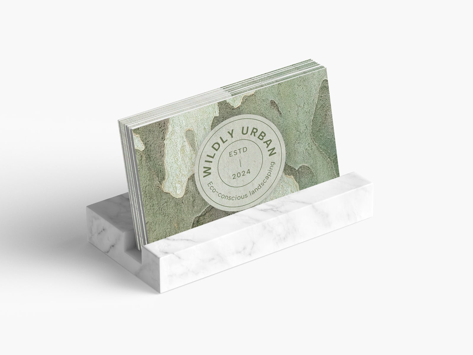 A standard business card sits in a marble business card holder.