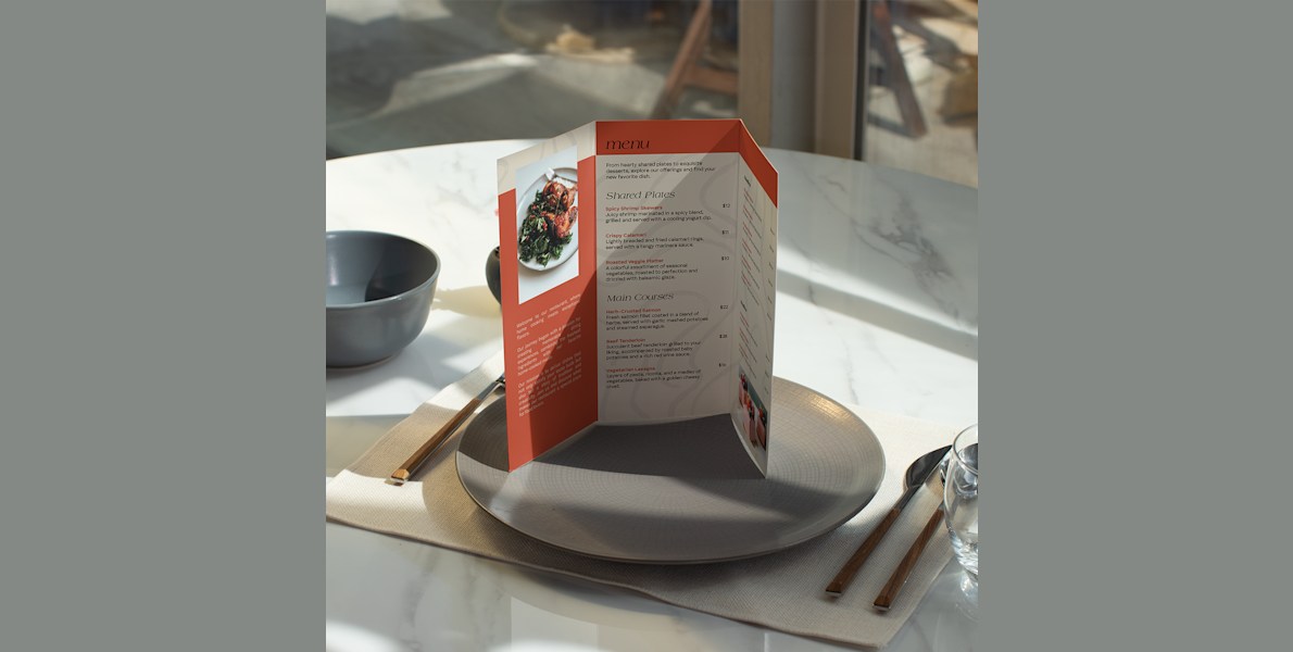 Larger version: An opened tri-fold menu, standing at a place setting at a restaurant.