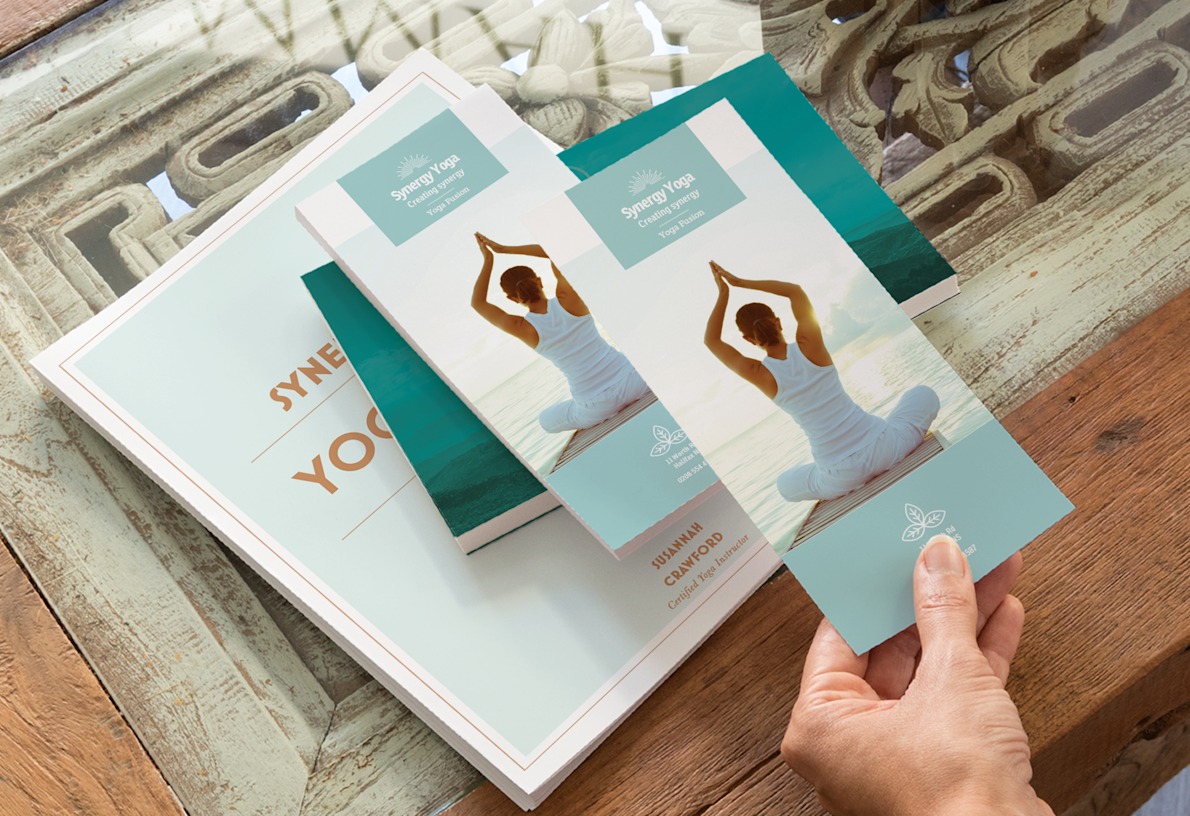 A hand holding a vertical business flyer promoting a yoga studio.  