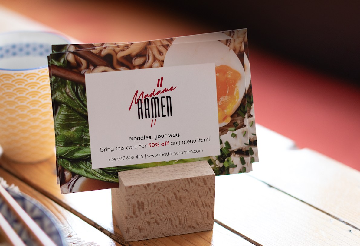 A few small horizonal leaflets in a wooden stand, promoting a restaurant.  