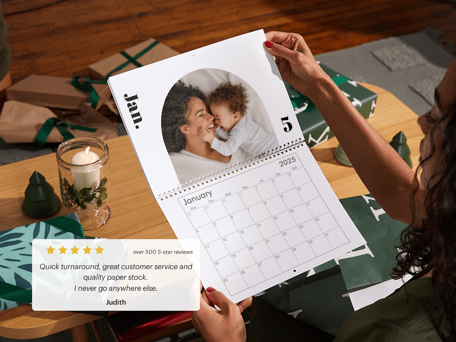 A pair of hands holding a personalised wall calendar that features a photo of a mother and baby. 