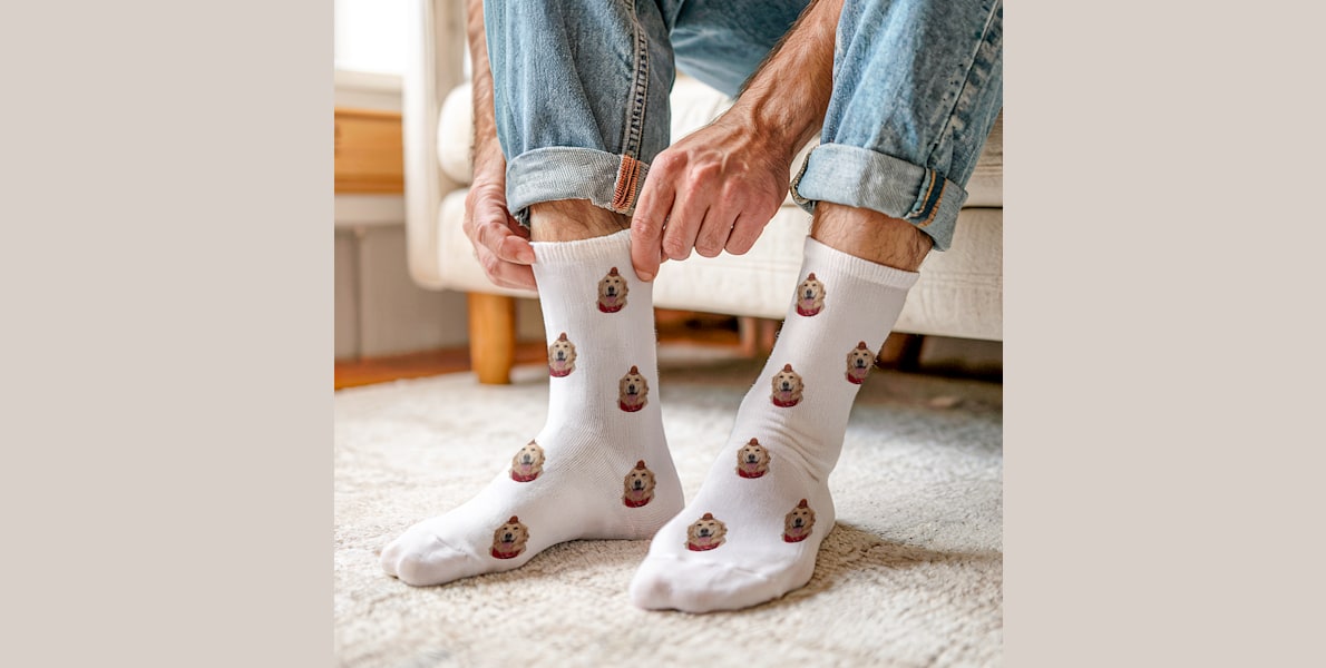 Larger version: A pair of feet wearing personalised socks featuring photos of a golden retriever. 