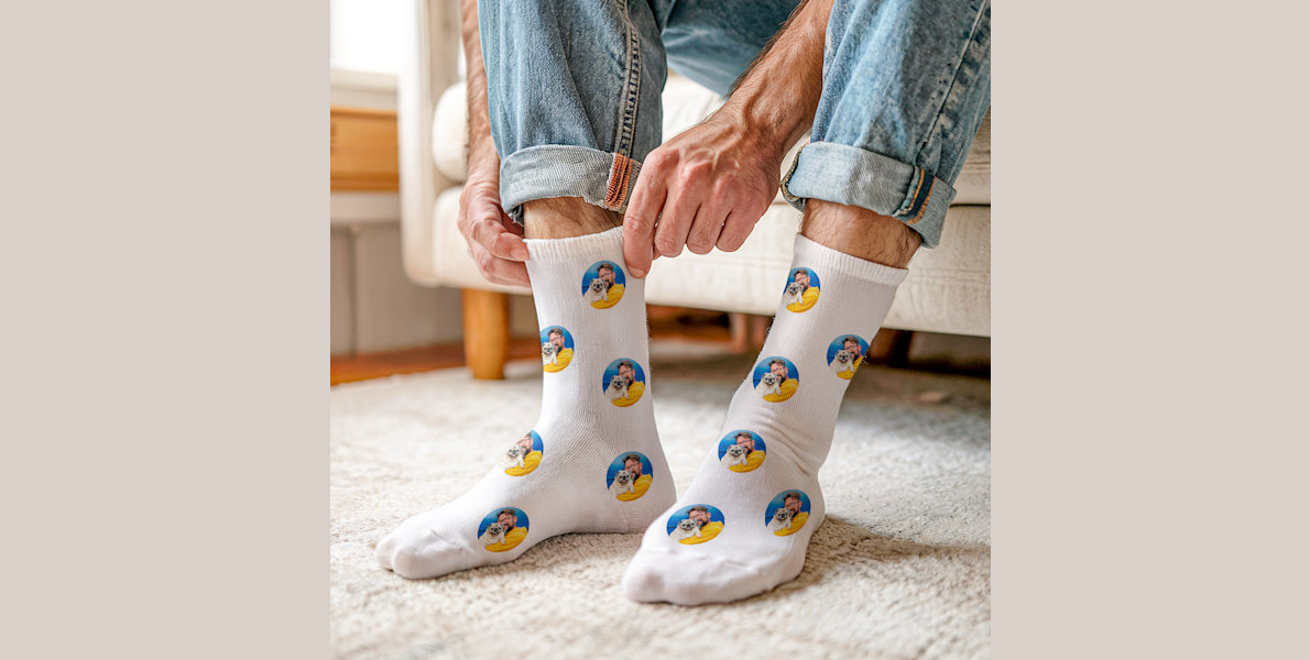 A pair of feet wearing personalised socks featuring photos of a young couple. 