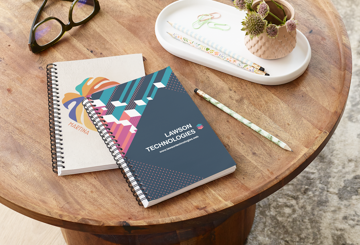 Two custom notebooks sitting on a table.