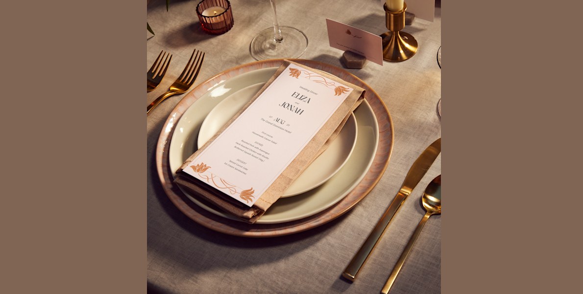 A wedding menu with white and rose gold flowers.