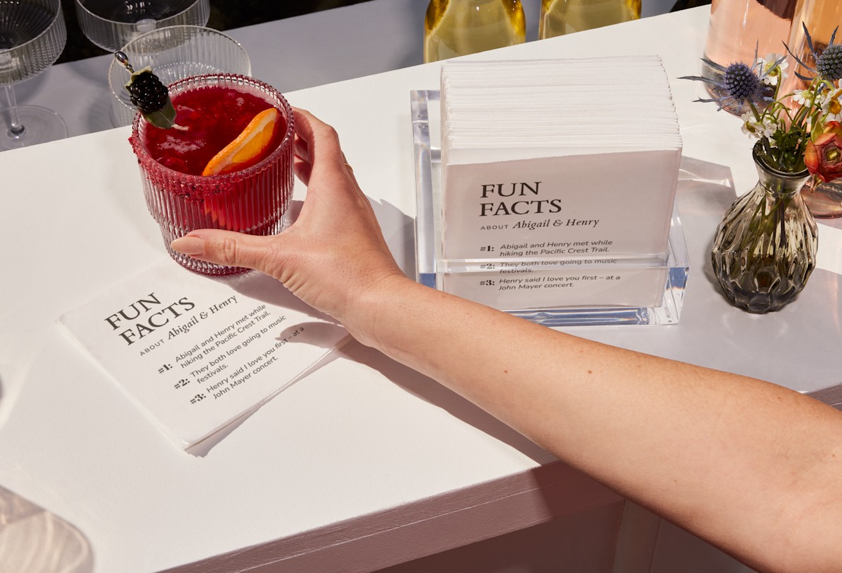 Larger version: A collection of cocktail napkins personalized for a wedding, printed with fun facts about the bride and groom. 