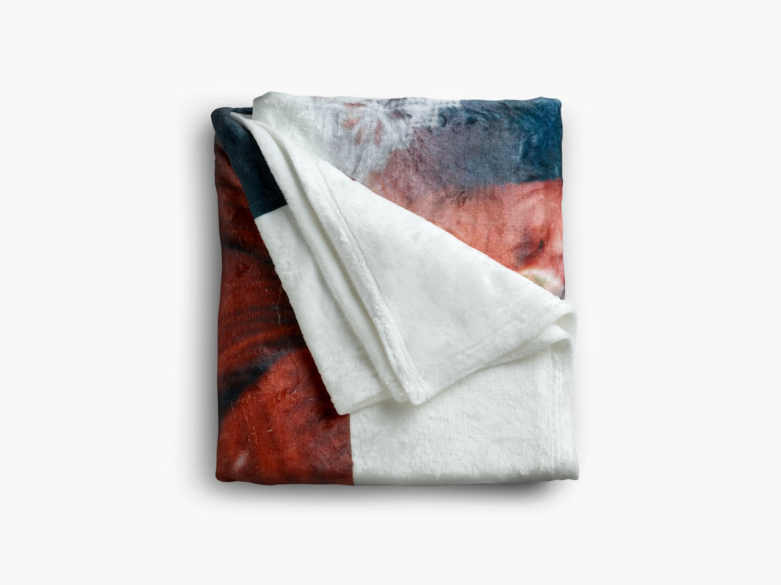 A photo blanket with red, green and white is folded into a neat square.