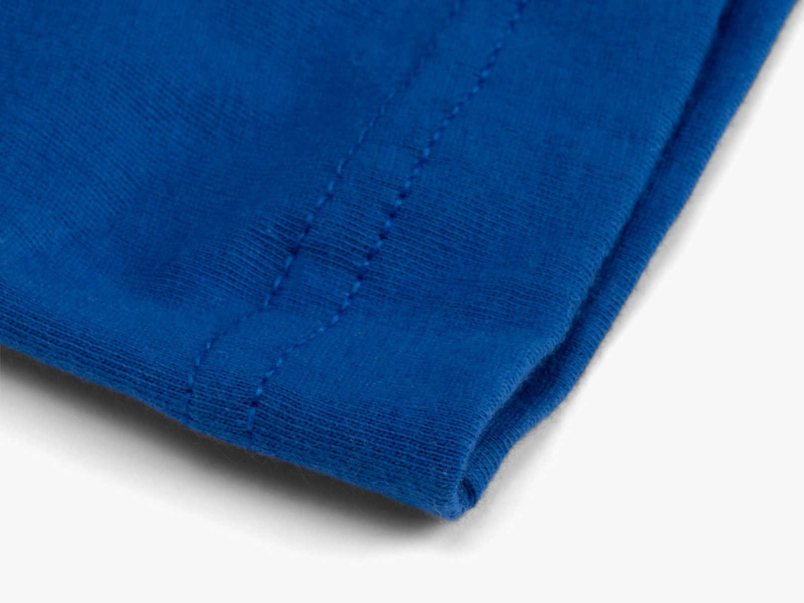 The bottom hem of a blue cotton T-shirt. 
