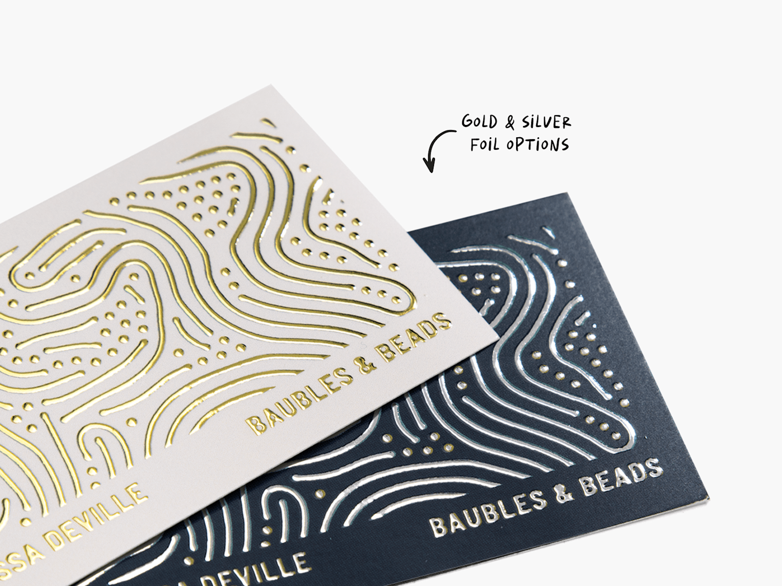 Raised foil business cards promoting a jewelry store, showing the gold and silver foil options.