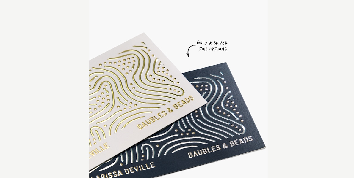 Raised foil business cards promoting a jewelry store, showing the gold and silver foil options.