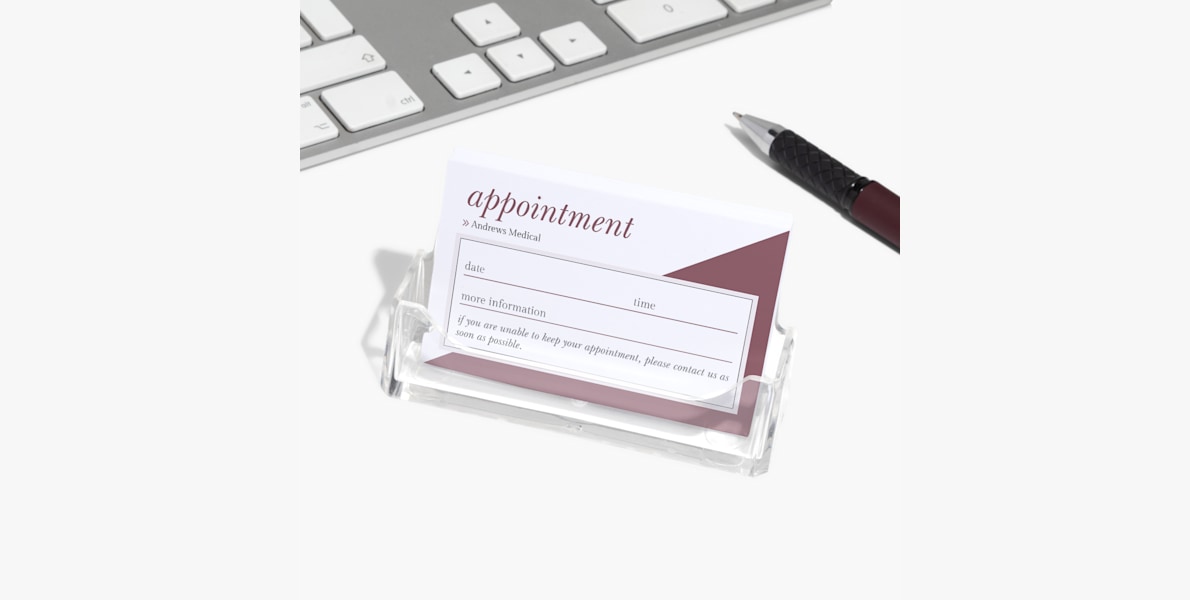 An acrylic business card holder holding appointment reminder cards for a medical clinic.
