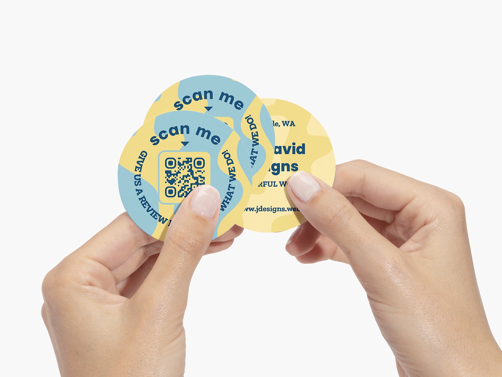  A person holding three circle business cards with QR codes in the design.