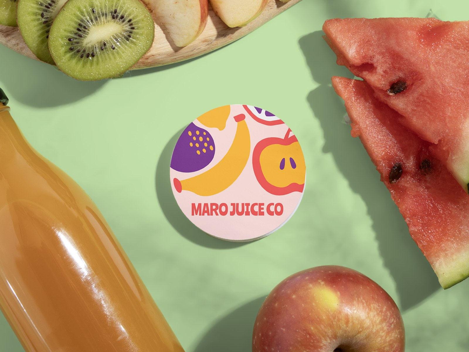 A stack of circle business cards for a juice company. The circle cards are sitting next to fresh fruits and a bottle of juice.