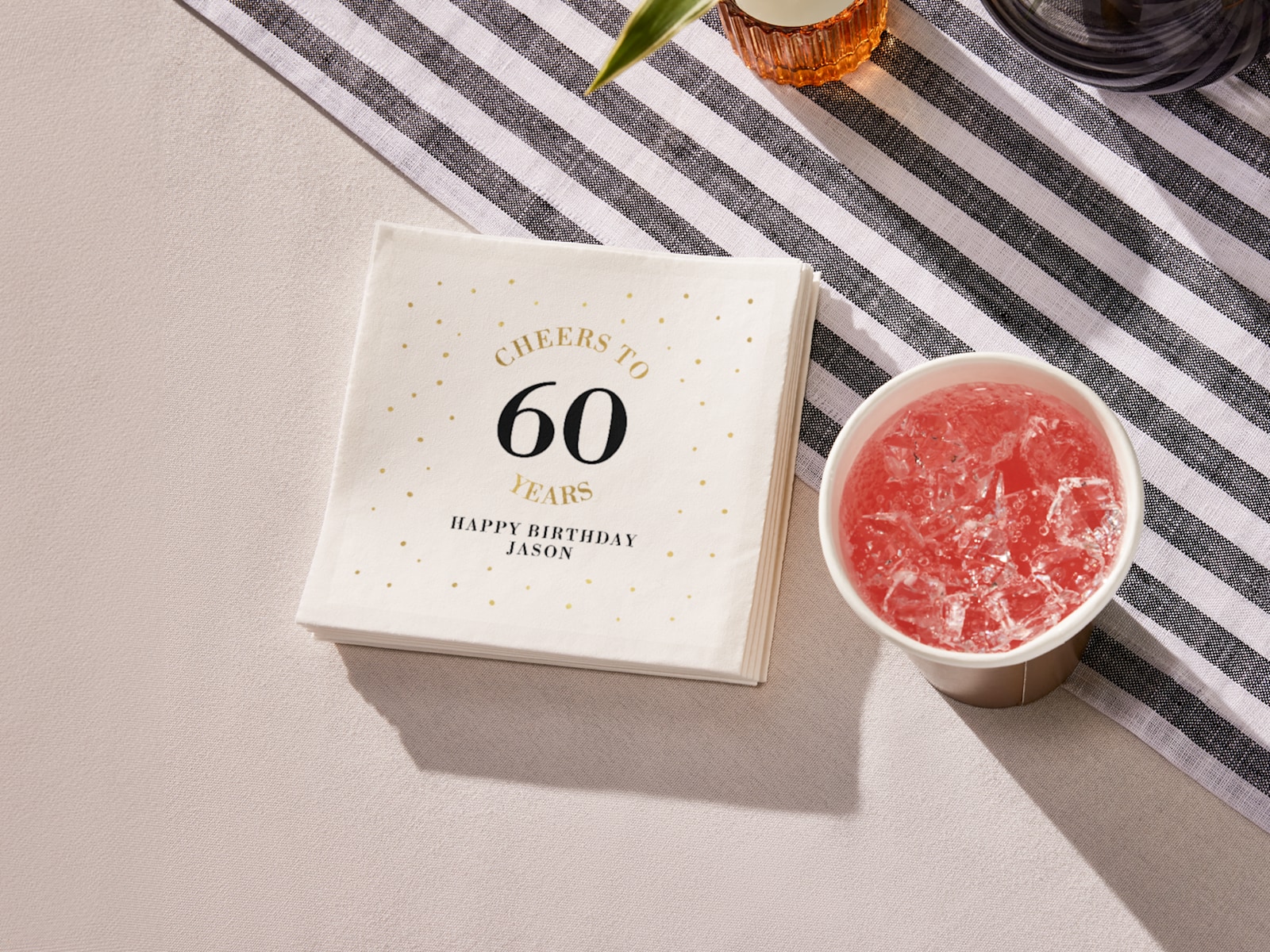 A stack of cocktail napkins personalized for a 60th birthday party. 
