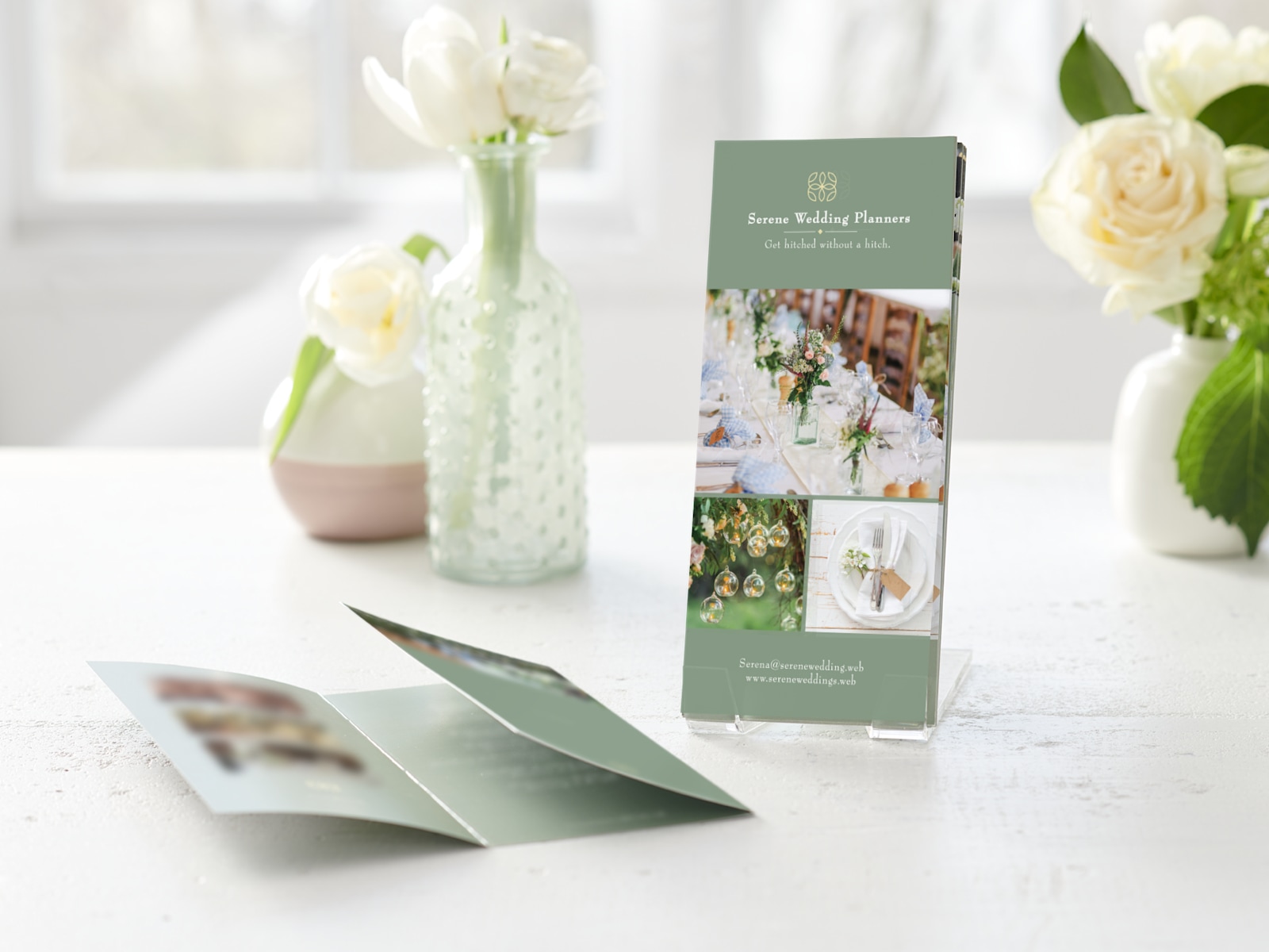 Several tri-fold menus for a wedding planning company, displayed in a clear plastic holder.  