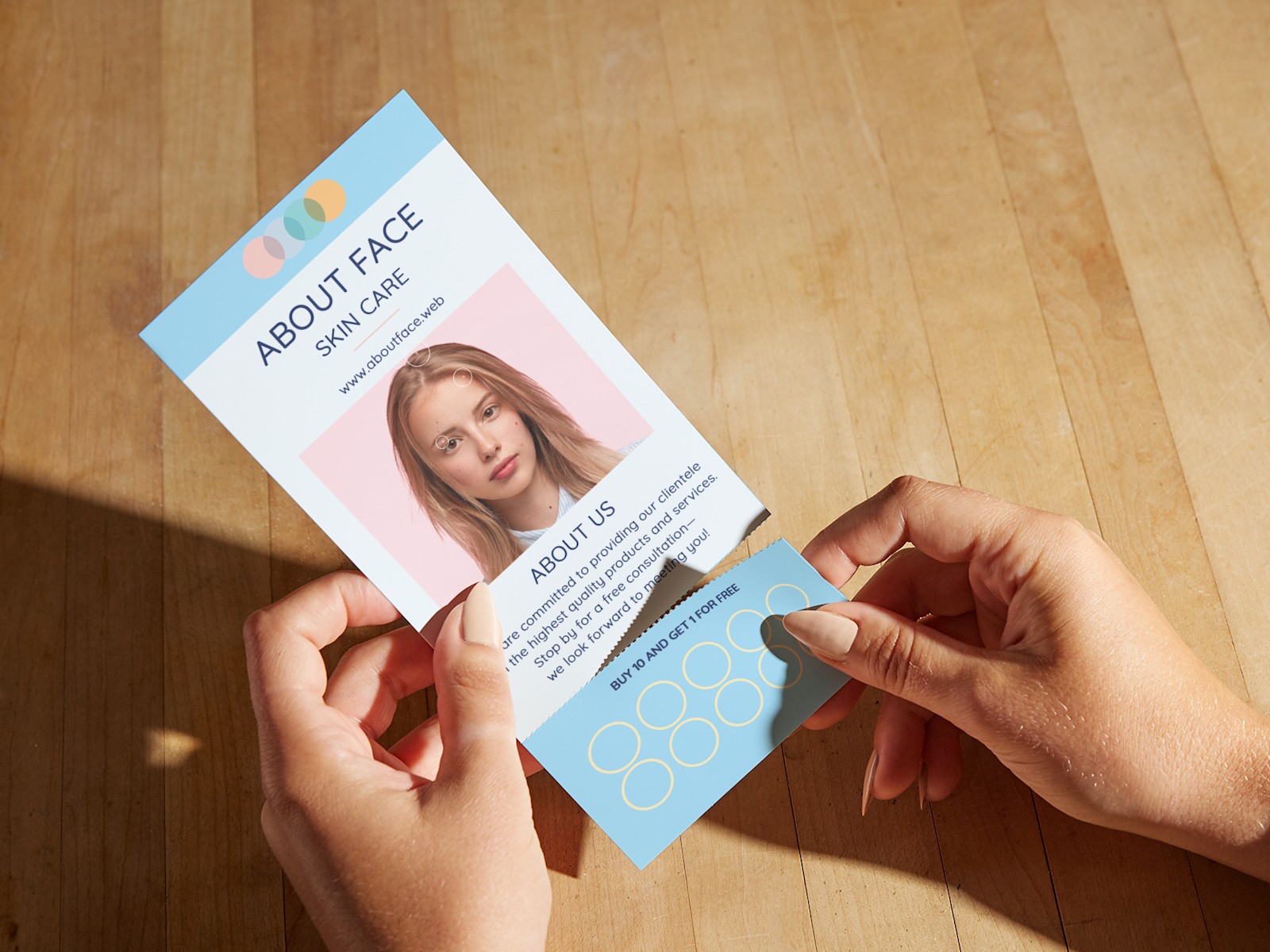 A person detaching a loyalty card from a rip card for skincare services. 