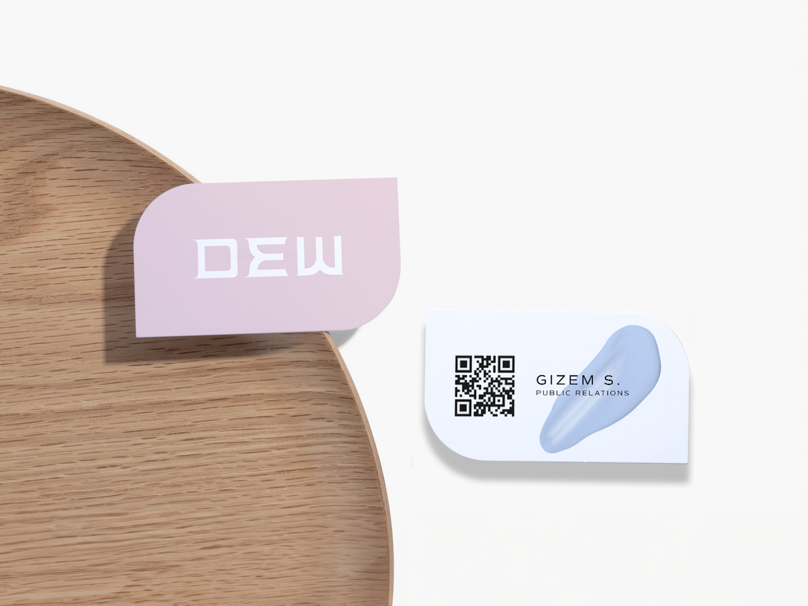 A front and back view of a leaf-shaped business card with a QR code for a public relations consultant.