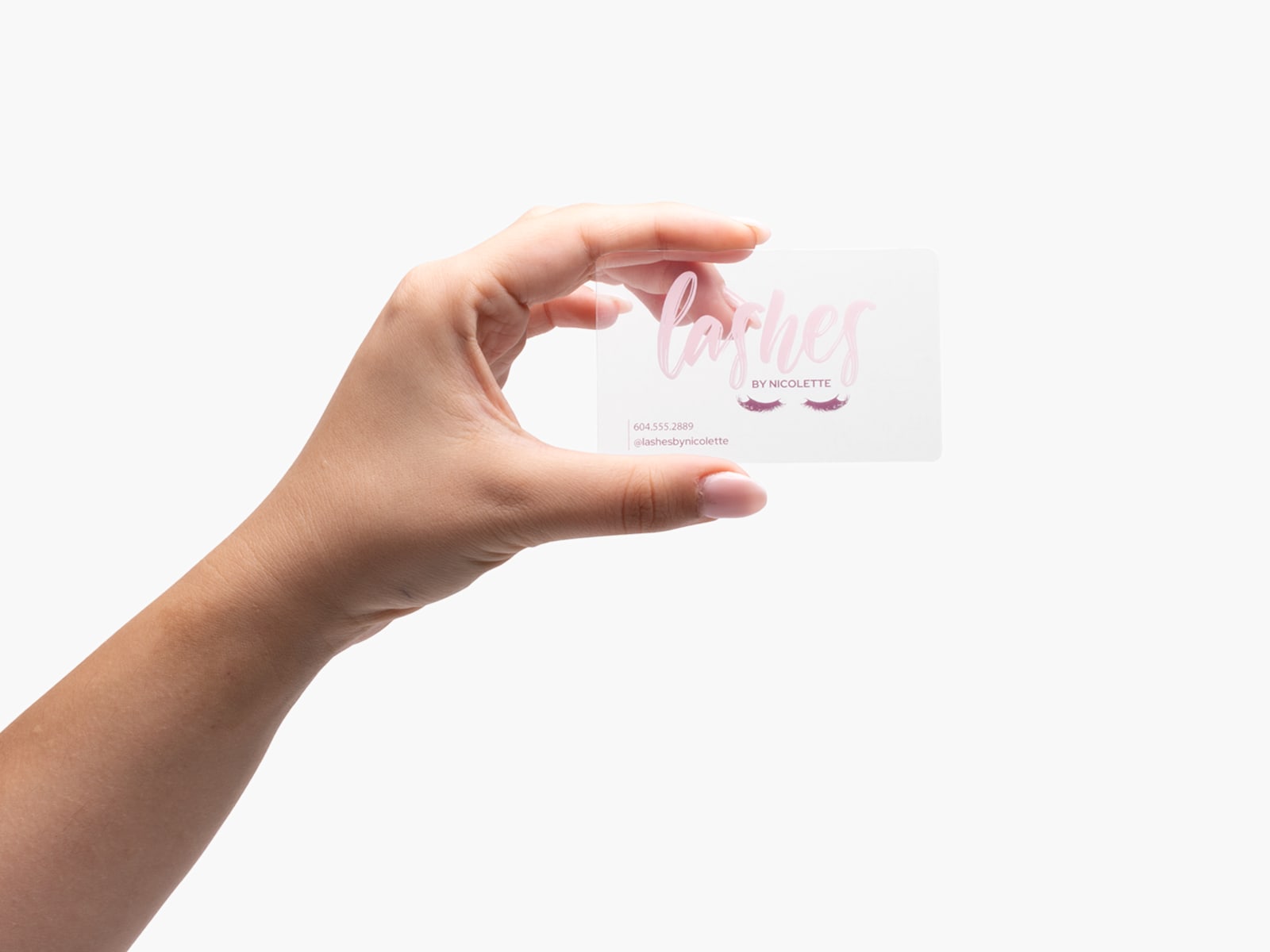 A person holding a clear plastic business card promoting an eyelash esthetician.