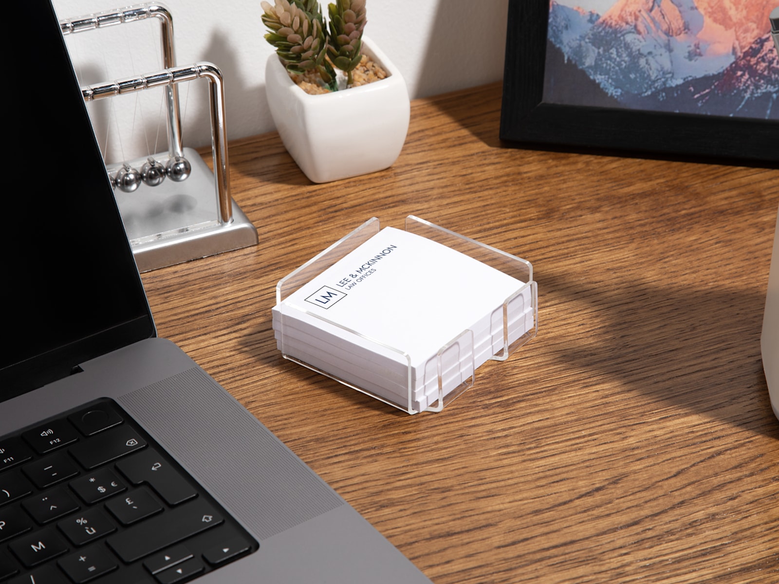 An acrylic Post-it® holder on a desk next to a laptop, filled with custom Post-it® Notes for a law office.