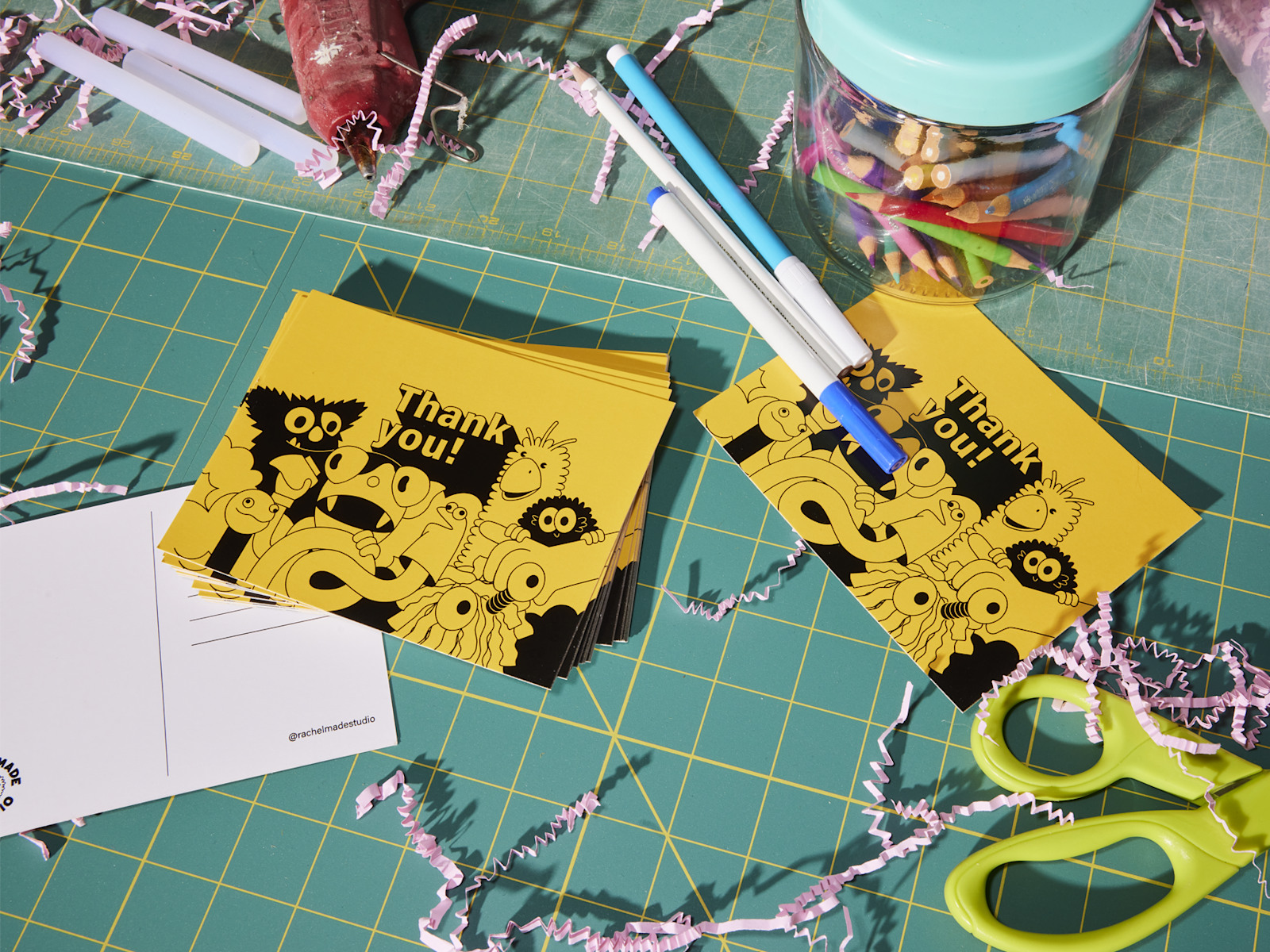 A stack of thank you postcards sitting on a crafting table.