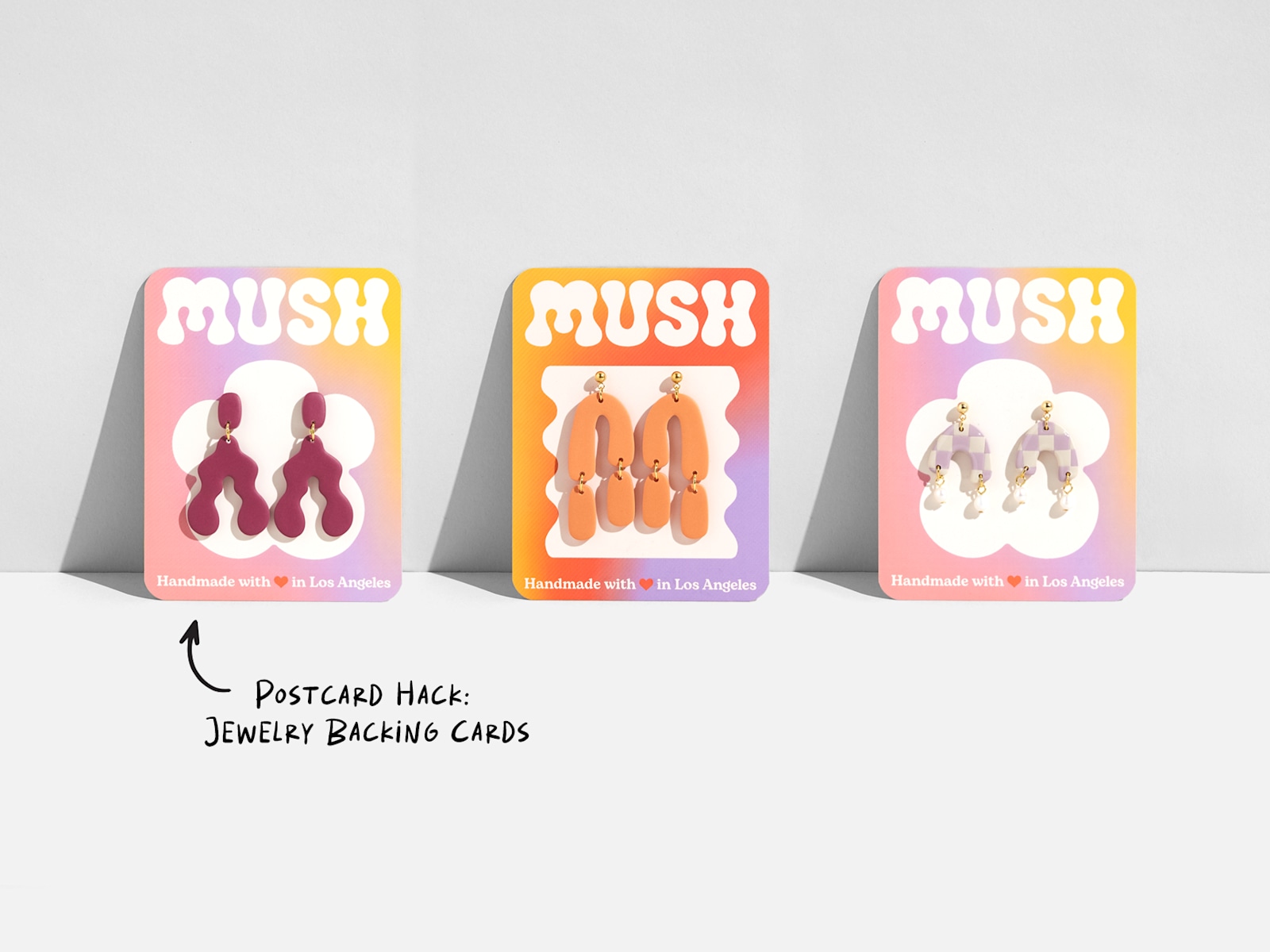 3 similarly designed postcards being used as jewelry backing cards.