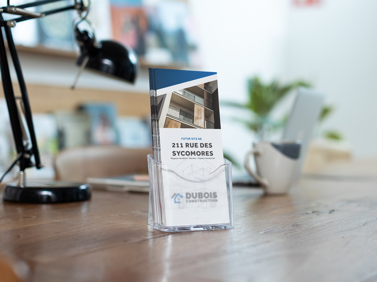 A stack of Z-fold brochures for a construction company, placed in a clear brochure holder at an office.