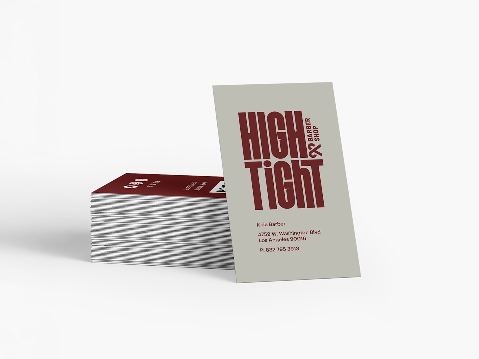 A stack of business cards for a barber, with one card standing upright.