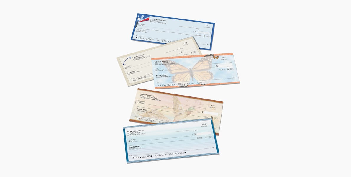 An assortment of personal wallet checks in various colors and designs, stacked in an overlapping arrangement.