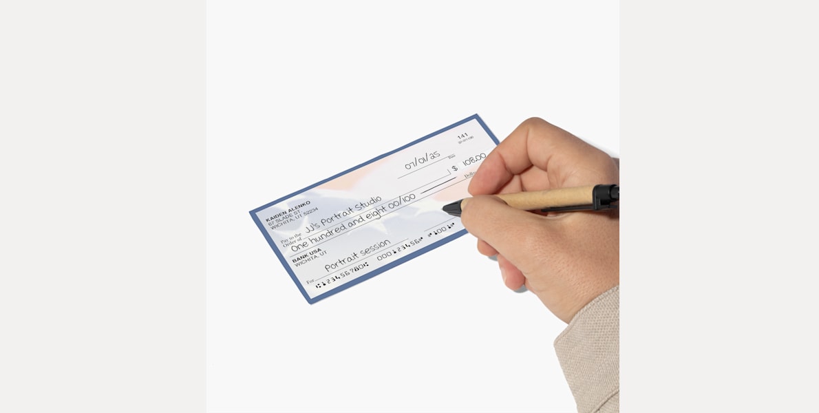 A person filling out a wallet check with their payment info.