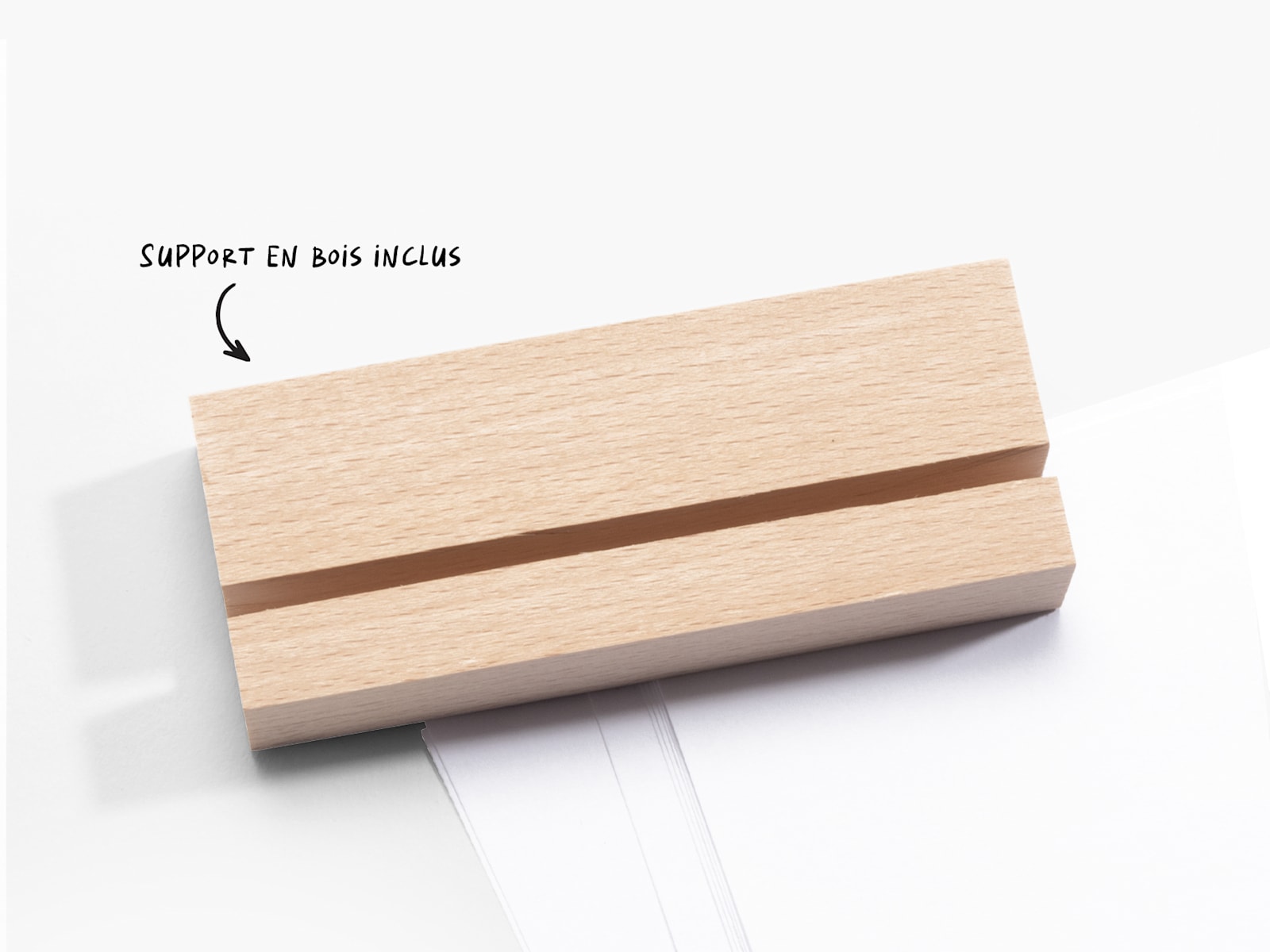 Un support en bois avec une fente où placer une plaque photo, avec une note indiquant que le socle en bois est inclus. 