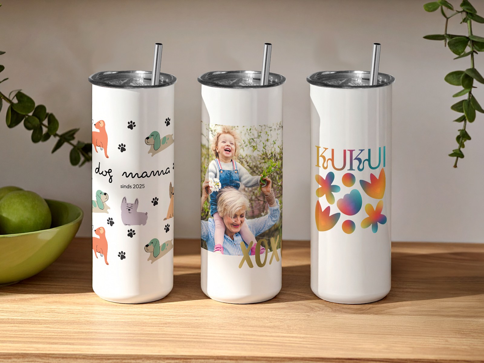 Drie gepersonaliseerde reisbekers, bedrukt met verschillende ontwerpen: diverse hondenpictogrammen, een familiefoto en een bedrijfsnaam. 