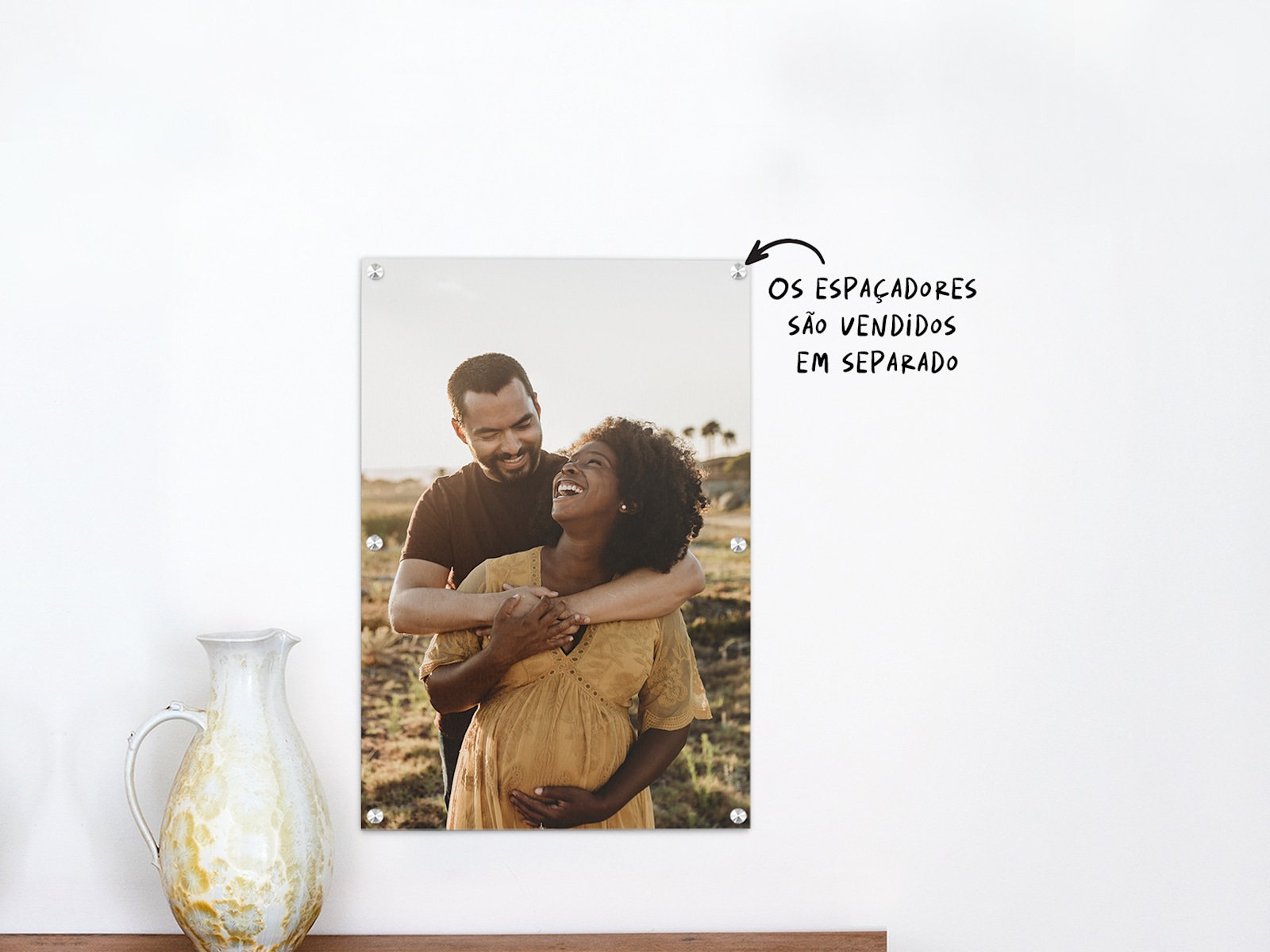 Uma impressão em acrílico que mostra a fotografia de maternidade de um jovem casal. 