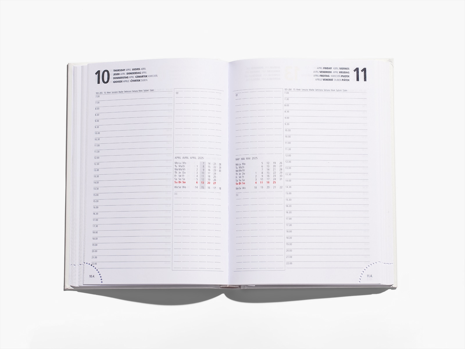Uma agenda com capa dura aberta com uma nota a mostrar o marcador de livro e outra chamada de atenção sobre os cantos perfurados.