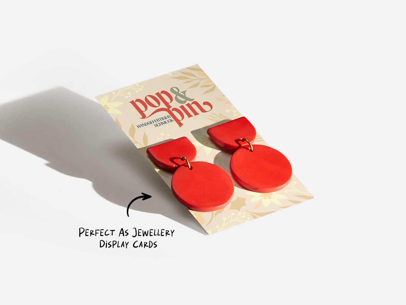A business card promoting a jewellery store, doubling as a display card for earrings.