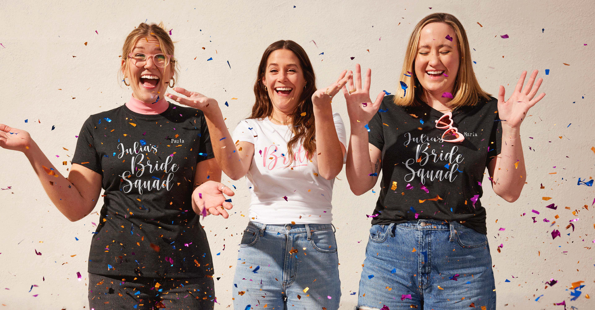 Chicas alegres con camisetas de mujer entalladas de Fruit of the Loom® a juego, divirtiéndose con confeti de colores y celebrando una fiesta de boda.