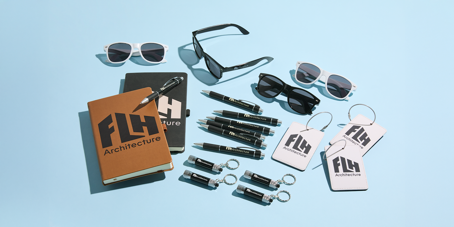 An assortment of new arrival promotional products, including custom sunglasses, pens and keychains.