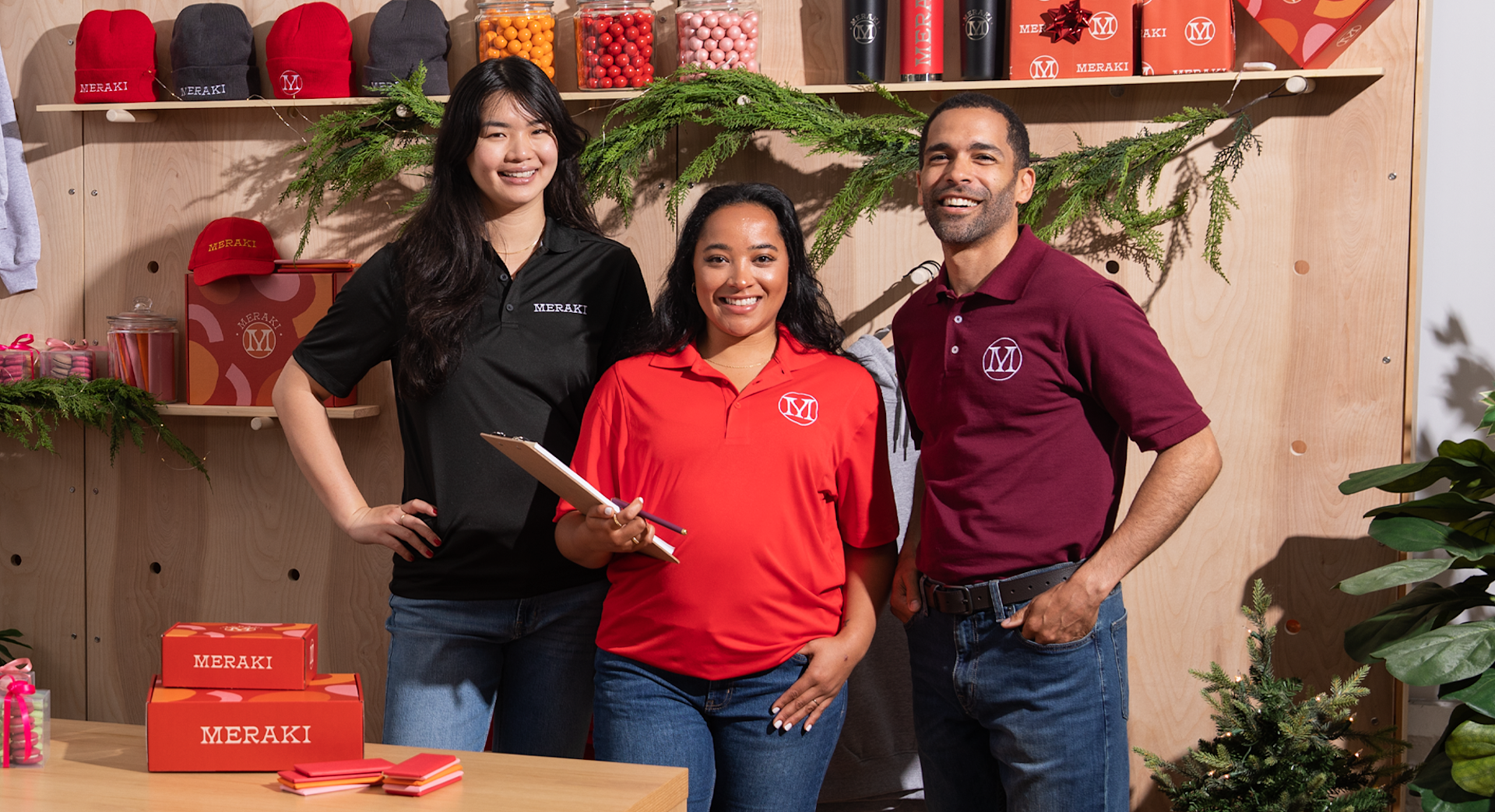 Three people standing together wearing branded polo shirts in different colors.