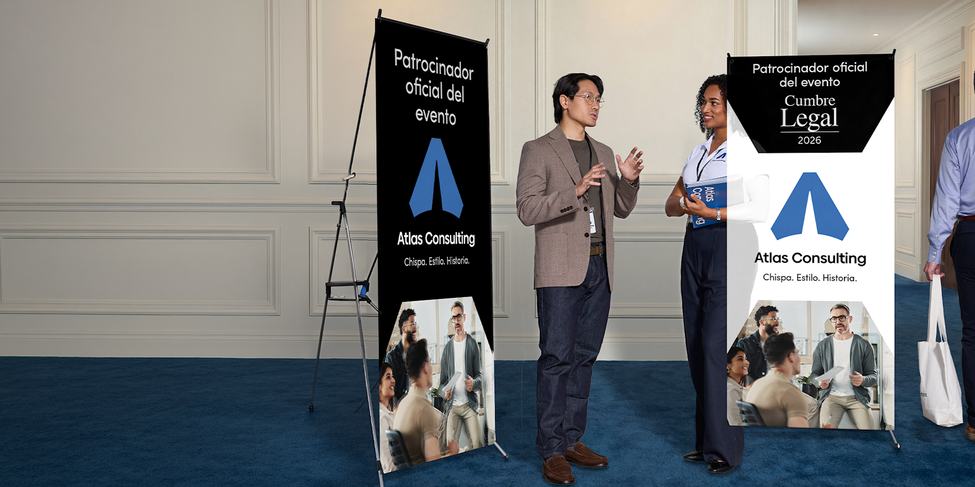 Dos personas estableciendo contacto en un evento profesional, con dos lonas promocionales al fondo.
